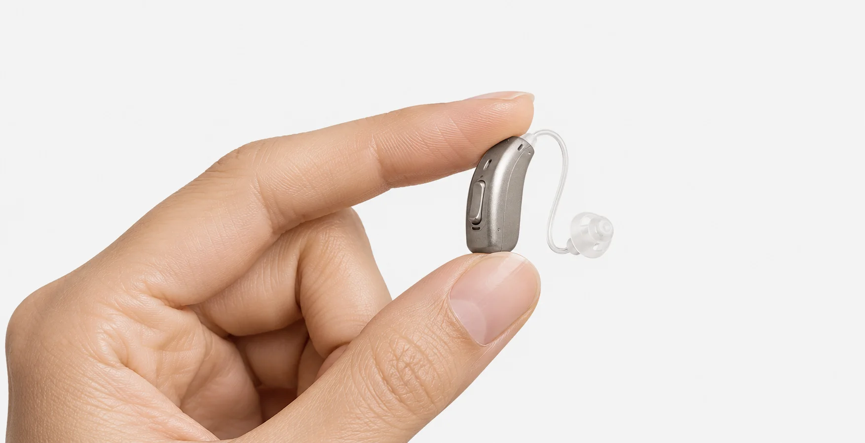 A close-up of a hand holding a small hearing aid